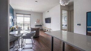 A modern apartment with a balcony, a dining area, a living room, and a kitchen. - Landing | Modern 1BD, Pool, Gym (Houston)