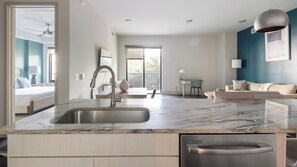Uma cozinha moderna com lava-louças embutida, uma pia grande e uma área de refeições com mesa e cadeiras.