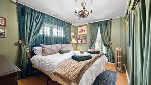 A neatly arranged bedroom with a bed, bedside tables, a radiator, and curtains. - Downtown St. Charles: Walk to Bars & Restaurants (St. Charles)