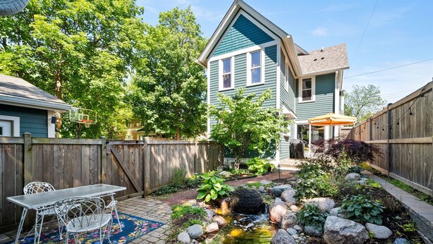 A backyard with a small pond, a wooden fence, and a house with a blue exterior. - Downtown St. Charles: Walk to Bars & Restaurants (St. Charles)