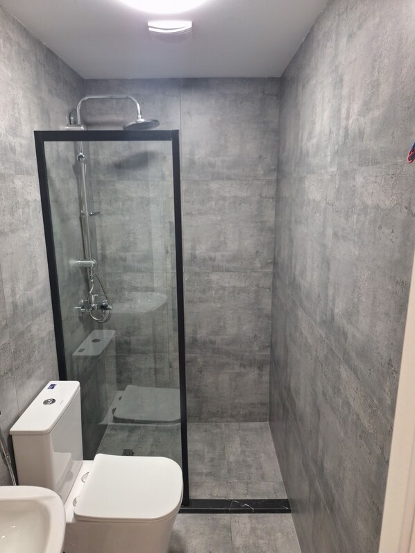 A modern bathroom with a glass-enclosed shower, a white toilet, and a sink. - Alara Inn Hostel & Hotel Baku (Baku)