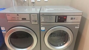 Two front-loading washing machines with digital displays and control panels. - YunLong HOTEL (Ongniud Banner)