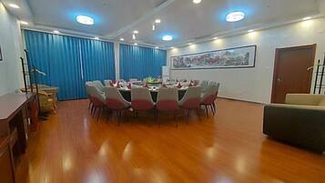 A conference room with a round table, chairs, and a sofa.