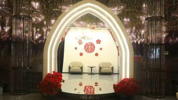 A stage with a circular emblem, two chairs, and red flowers.