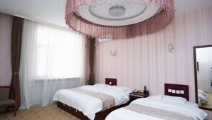 A hotel room with two beds, a wooden chair, a bedside table with a lamp, and a large mirror on the wall. - YunLong HOTEL (Ongniud Banner)