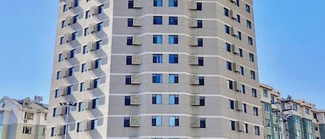 A multi-story hotel with a modern design, featuring a series of balconies and a prominent entrance.