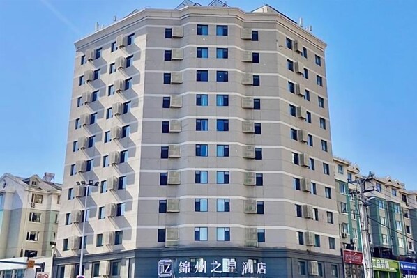 Un hôtel à plusieurs étages, doté d’un design moderne, avec une série de balcons et une entrée imposante.