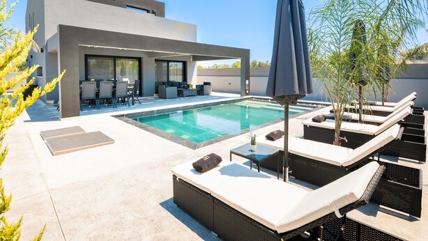 A modern outdoor pool area with a lounge, seating, and a pergola. - Hollywood 3 Bedroom Villa with private pool (Ampelokipoi)