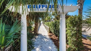 Un sentier menant à une plage privée, avec un panneau indiquant : « PLAGES PRIVÉES DE GULFPLACE ».