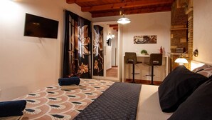 A hotel room with a bed, a desk, and a dining area. - MATEO Studio with Terrace (Rovinjsko Selo)