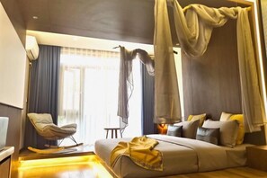 A modern bedroom with a sofa bed, a rocking chair, and a canopy bed. - Yinan Inn (Dujiangyan)