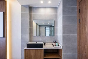 A modern bathroom with a rectangular sink, a mirror above it, and a wooden cabinet below. - Yinan Inn (Dujiangyan)