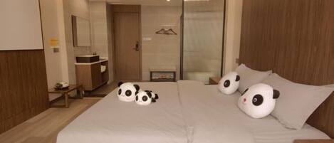 A bedroom with a bed, a bedside table, a mirror, and a wardrobe.