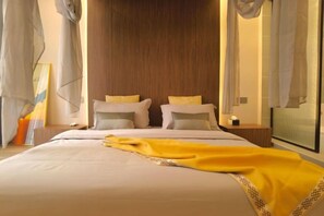 A hotel room with a large bed, a wooden headboard, and a window with curtains. - Yinan Inn (Dujiangyan)