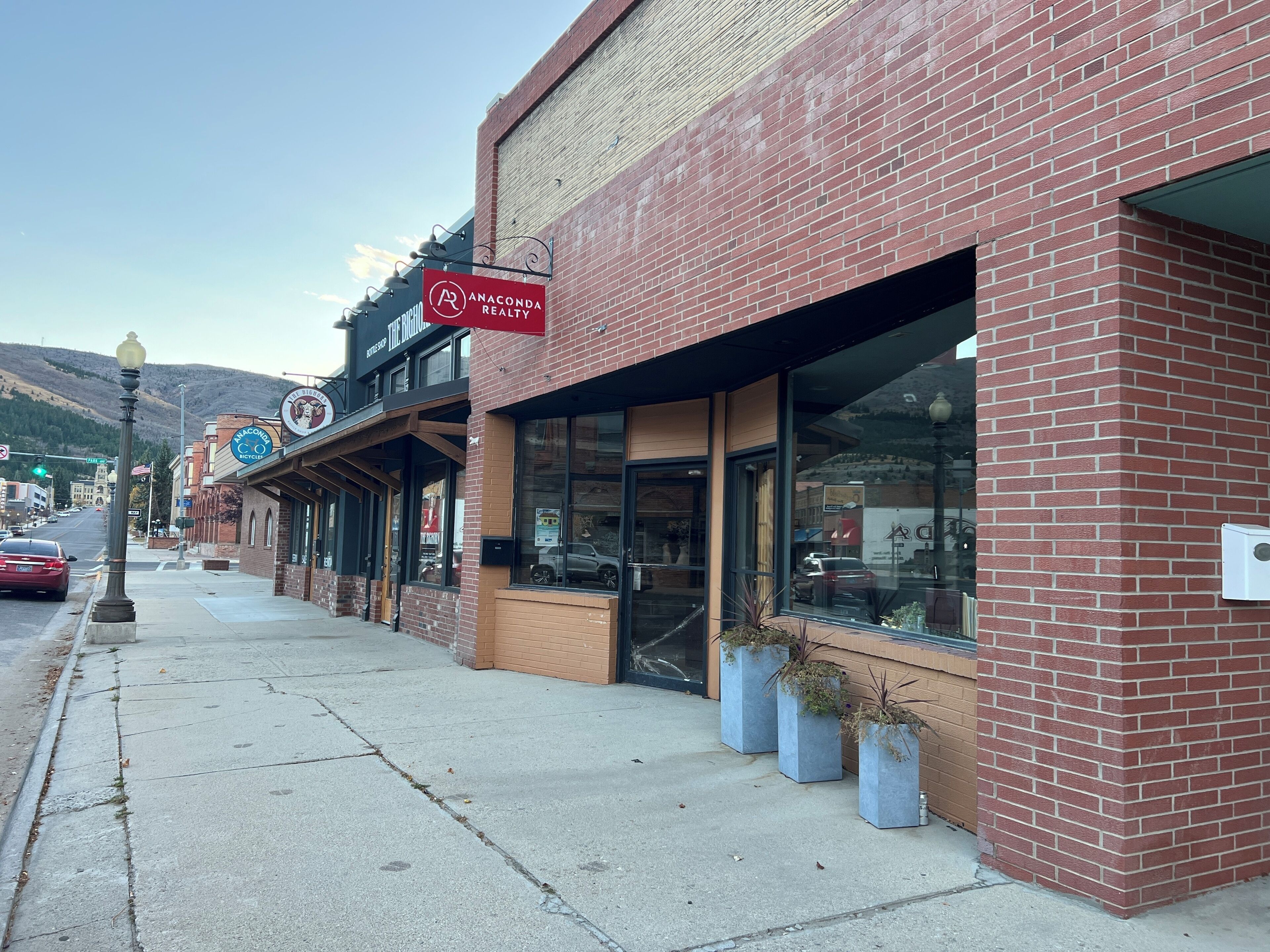 A brick building with storefronts, including Anaconda Realty and The King.