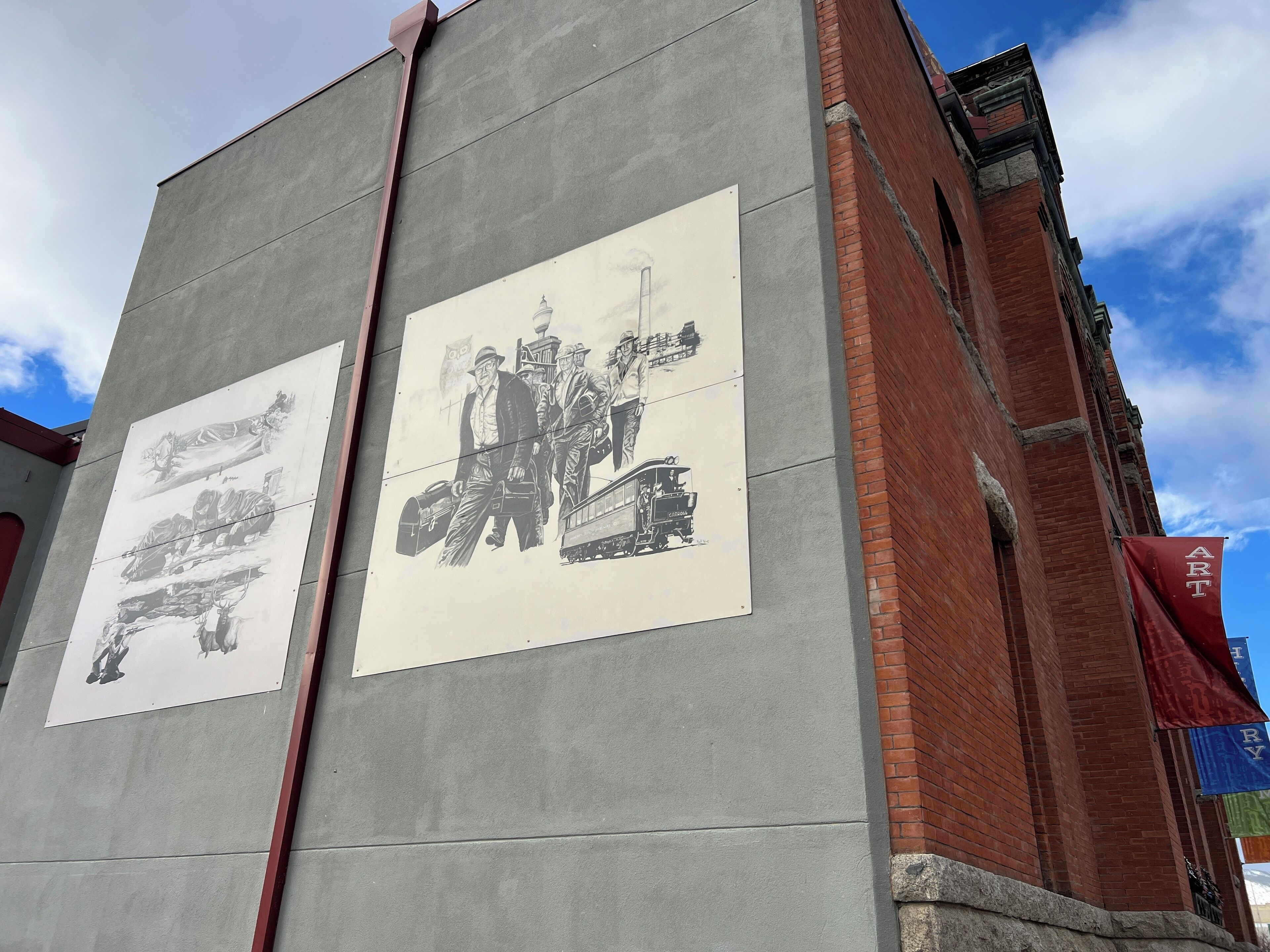 Een gebouw met twee grote zwart-wit posters op de gevel.