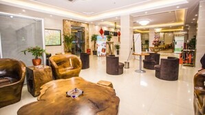 A modern lobby with leather chairs, a wooden coffee table, and potted plants. - Yihao Hotel (Shanghai Huinan subway station store) (Shanghai)