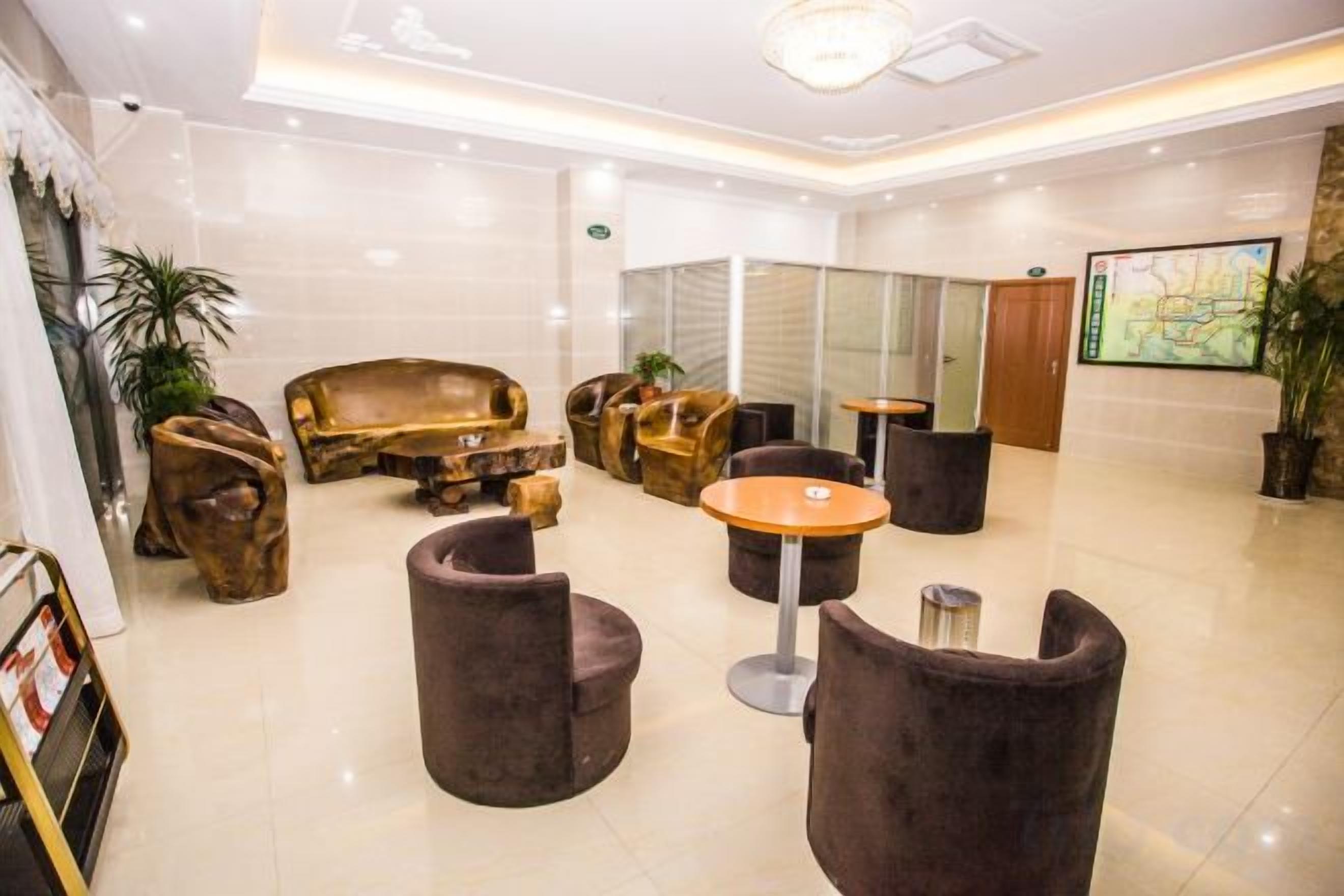 A hotel lobby with a reception desk, seating area with sofas and chairs, and a large map on the wall.