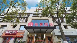 A hotel with a prominent sign, a glass entrance, and a tree in front. - Yihao Hotel (Shanghai Huinan subway station store) (Shanghai)