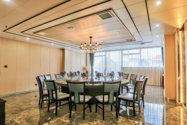 A conference room with a round table, chairs, and a chandelier.