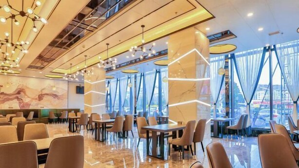 A modern restaurant with a polished marble floor, contemporary furniture, and large windows offering a city view.