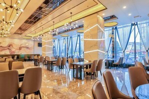 Um restaurante moderno com piso de mármore impecável, mobiliário contemporâneo e grandes janelas com vista para a cidade.