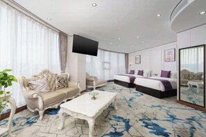 A hotel room with a sofa, a bed, a television, and a large window. - Zhuanghe Hualin Hotel (Zhuanghe)