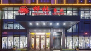A hotel entrance with a glass facade and a sign indicating it is a hotel and catering service.