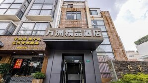 A hotel entrance with a modern facade, a visible staircase, and a signboard with text. - Yizhou Hotel (Shanghai)