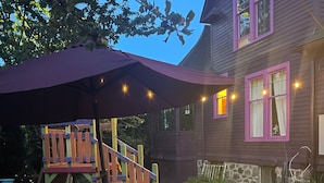 A wooden deck with a picnic table, a swing set, and a house with purple-framed windows. - 5-min walk to Downtown Olympia and Capital Lake, 4br, sleeps 13 (Olympia)