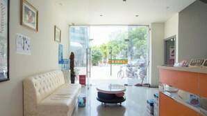 A hotel lobby with a sofa, a coffee table, and a reception desk. - Chaolv 98 Hostel (Shanghai University) (Shanghai)