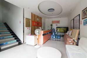 A hotel lobby with a reception desk, a staircase, and a seating area. - Chaolv 98 Hostel (Shanghai University) (Shanghai)