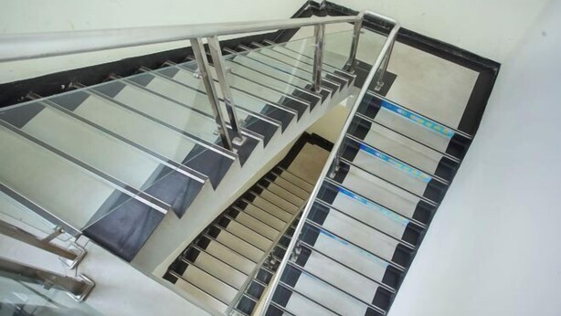 A staircase with metal railings and glass panels. - Chaolv 98 Hostel (Shanghai University) (Shanghai)