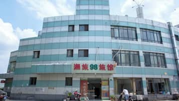 Un edificio de varios pisos con un letrero que indica un comercio o establecimiento de servicios.
