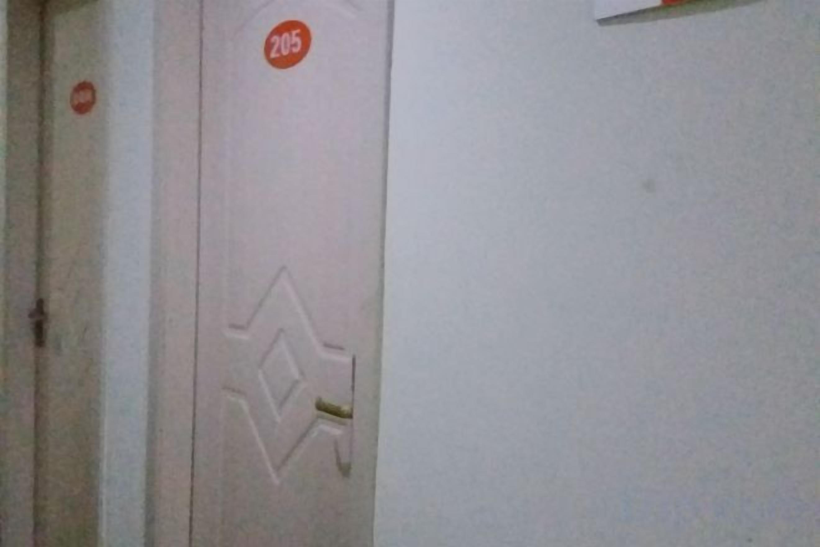 A door with a number plate and a geometric design.