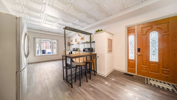 A kitchen with a wooden island, a refrigerator, and a wooden door with stained glass windows. - 5BedR, Sleeps 16, Big Yard, Game Room, Pet OK, CVNP (Cuyahoga Falls)