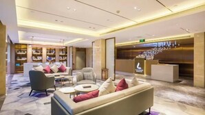A modern lobby with a sofa, chairs, a coffee table, and a reception desk. - Lavande Hotel (Beijing Guomao) (Beijing)