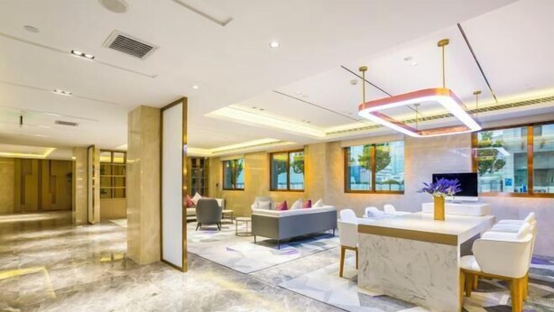 A spacious hotel lobby with a marble floor, a reception desk, seating area, and large windows offering a view of the outdoors. - Lavande Hotel (Beijing Guomao) (Beijing)