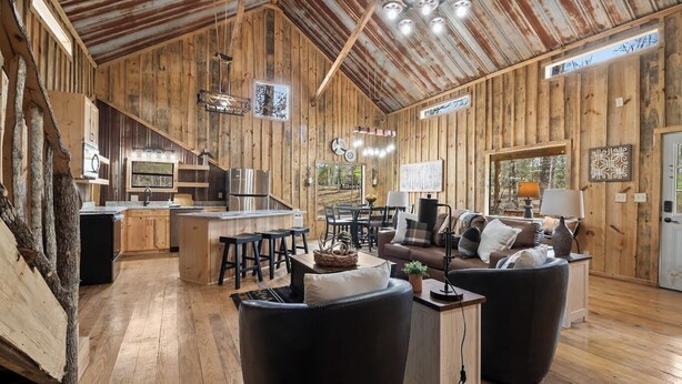 A rustic cabin interior with a kitchen, dining area, and living room.