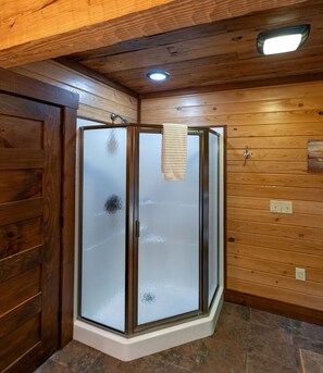 A corner shower with frosted glass doors, wooden walls, and a ceiling light. - Heavens Ridge-3-bedroom Pet Friendly Luxury Log Cabin Rental, Mountain Views, 30 Minutes to Great Smokey Mountains, High Speed Internet, 3 Decks, Hot Tub in Nantahala NC (Topton)