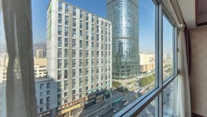 A high-rise building with a modern glass facade and a traditional building with a grid of windows.