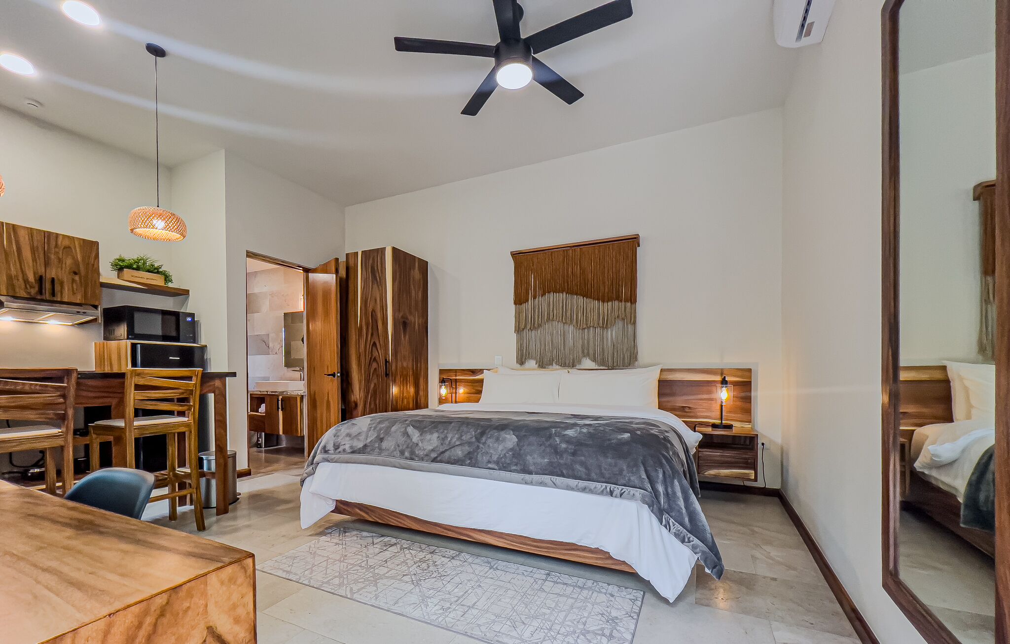 Une chambre moderne avec un lit, un bureau et un coin repas.