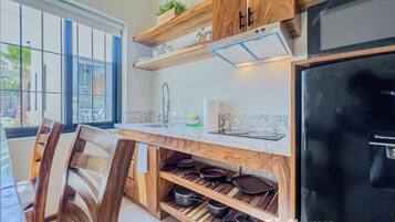 A kitchen with wooden cabinetry, a built-in stove, and a window with a view of the outside.