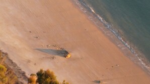 A beach with clear water and a sandy shore.