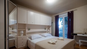 Ein Schlafzimmer mit einem Bett, Nachttischen, einem Schreibtisch und einem Kleiderschrank.