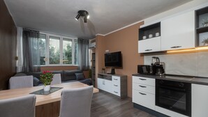 Eine moderne Küche mit weißen Schränken, einem eingebauten Backofen und einer Kaffeemaschine.