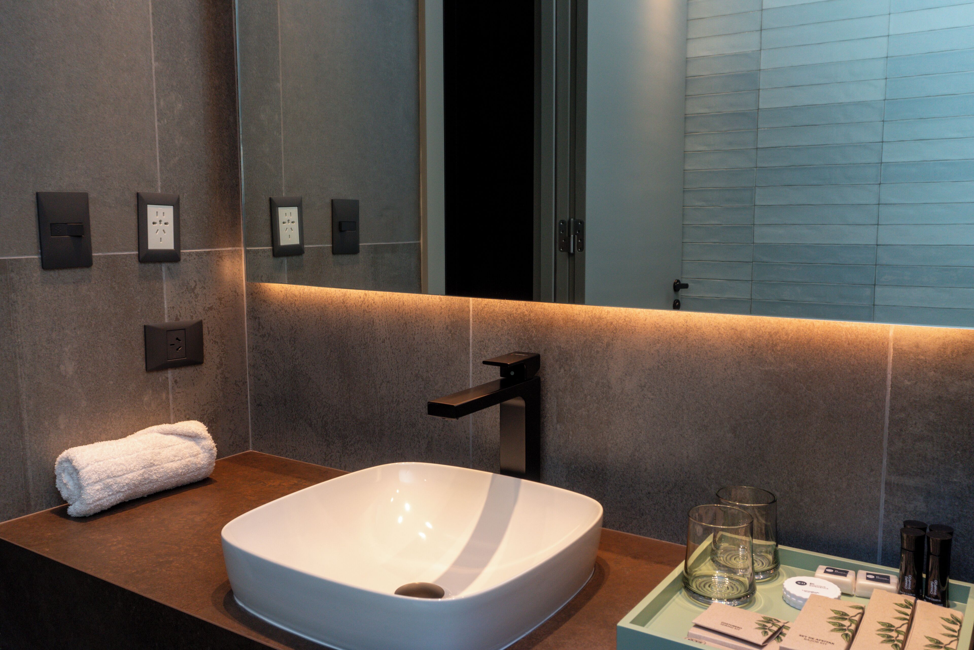 A modern bathroom with a large white sink, a towel, and a mirror.