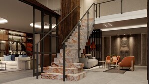Un intérieur moderne avec un escalier en marbre, un canapé et un fauteuil.