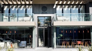 Un bâtiment moderne doté d’une façade en verre, d’une terrasse et d’une entrée bien visible.