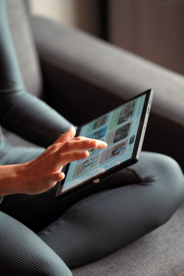 A person using a tablet on a couch. - Eh Boutique Experience (El Calafate)
